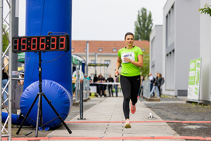 Laufteilnehmende rennen an der Campusachse entlang.