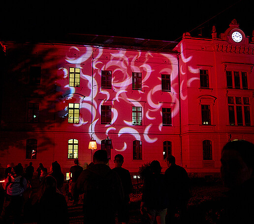 Ein rot angestrahltes Gebäude.