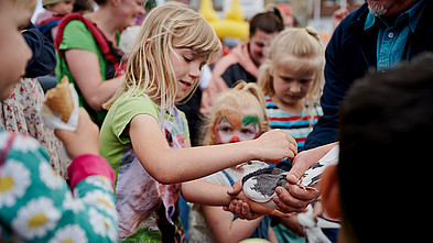 Ein Kind streichelt eine Taube beim Friedensfest.