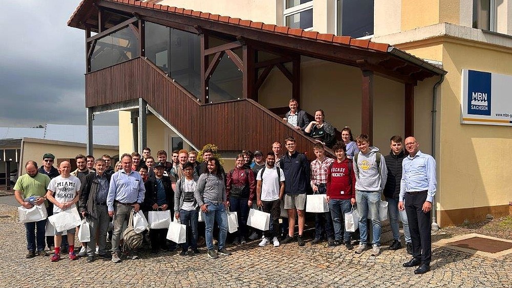 Gruppenfoto vor dem MBN-Firmengebäude mit Teilnehmenden der Exkursion