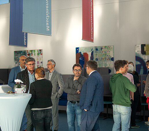 Gäste der Veranstaltung sind im Gespräch vertieft.