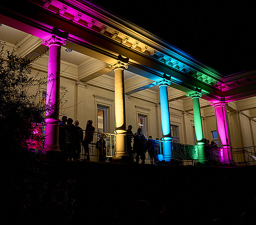 Die Säulen des Stadtbades erstrahlen in neonbunten Farben.