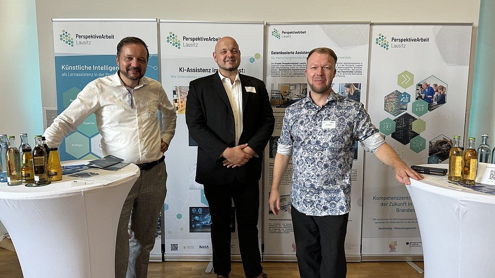 Tino Schmidt, Prof. Matthias Schmidt and David Sauer at the Oberlausitz Entrepreneurs' Forum. They are standing in front of roll-ups between two bar tables.