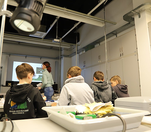 Schüler im Werkslabor der HSZG schauen nach vorn an die Beamerleinwand.
