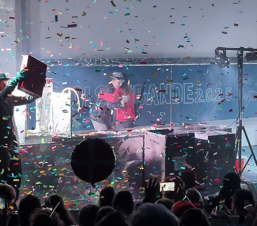 Im Konfettiregen umarmen sich zwei Darsteller.