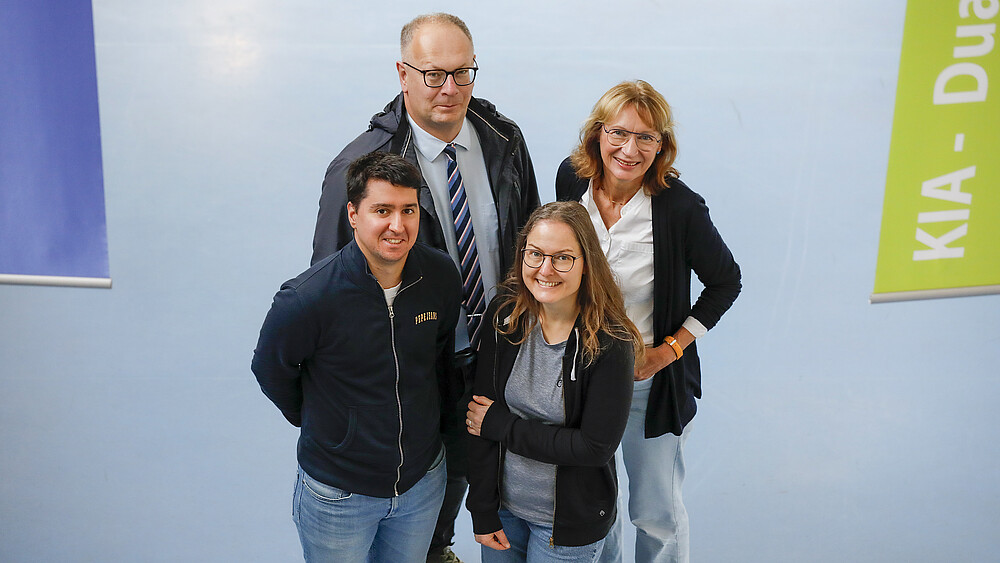 Das Projektteam steht im Foyer von Haus Z IV und schaut nach oben in die Kamera.
