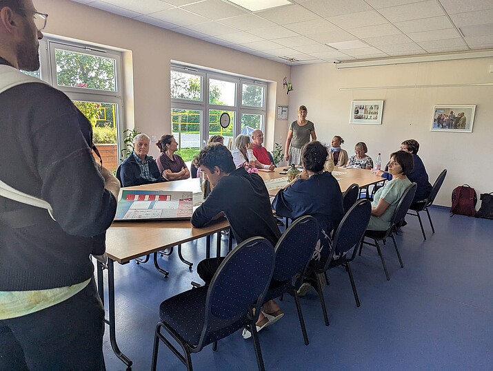 Mehrere Teilnehmende in einem Besprechungsraum am Tisch sitzend