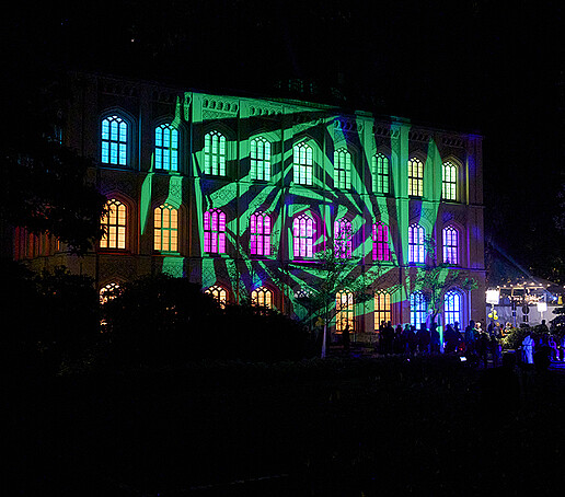 Der Heftergiebel ist grün, lila und gelb angeleuchtet.